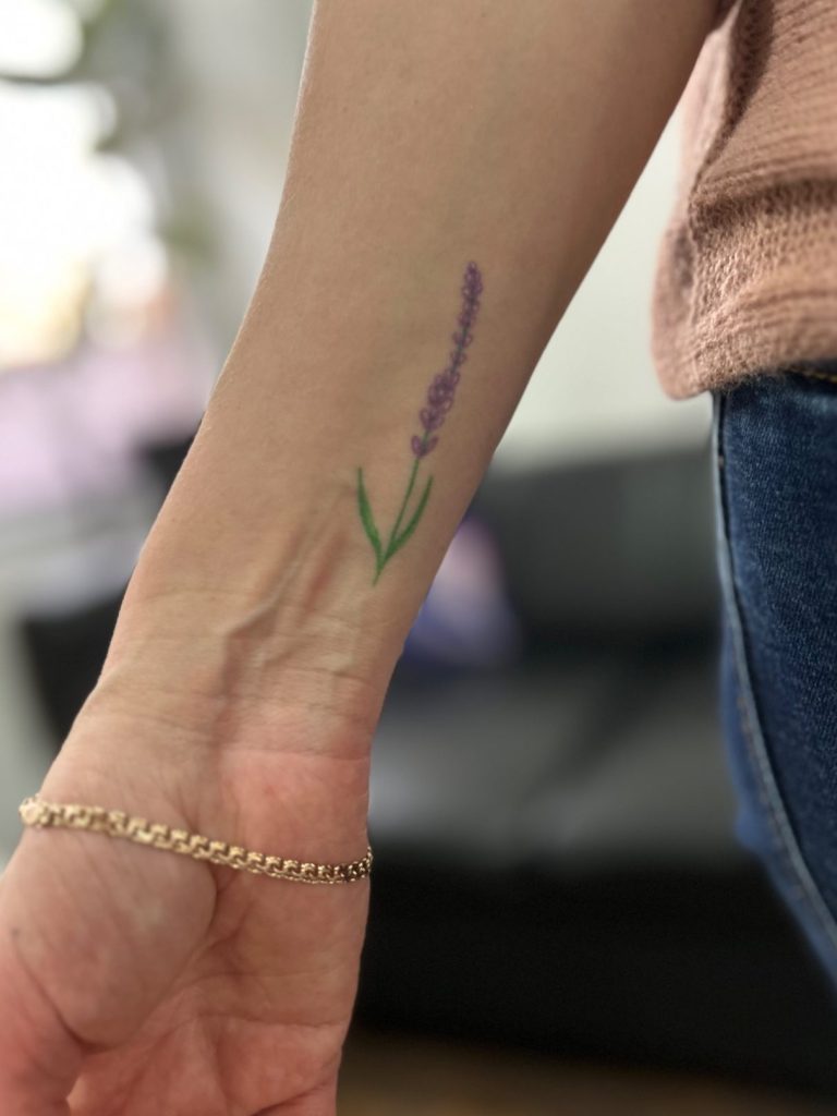 Kleines Fineline Lavendel Tattoo in Lila und Grün am Unterarm