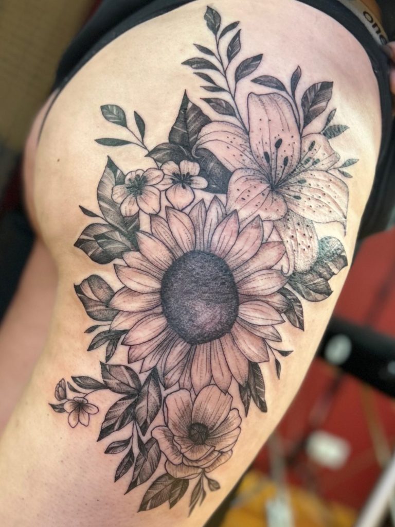 Großflächiges florales Fineline Tattoo mit Sonnenblume, Lilie und botanischen Elementen in Black and Grey