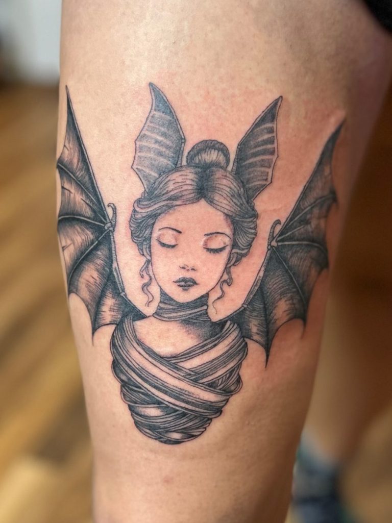 Illustratives Black and Grey Tattoo einer mystischen Figur mit Fledermausflügeln