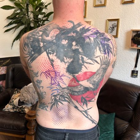 Rücken Tattoo nach umfangreicher Cover-up Überarbeitung mit Kranich und floralen Elementen sowie Polka Dot Stil