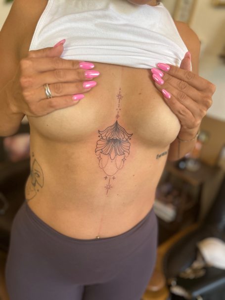 Ornamentales Fineline Tattoo am Bauch Underboob mit floralen Elementen