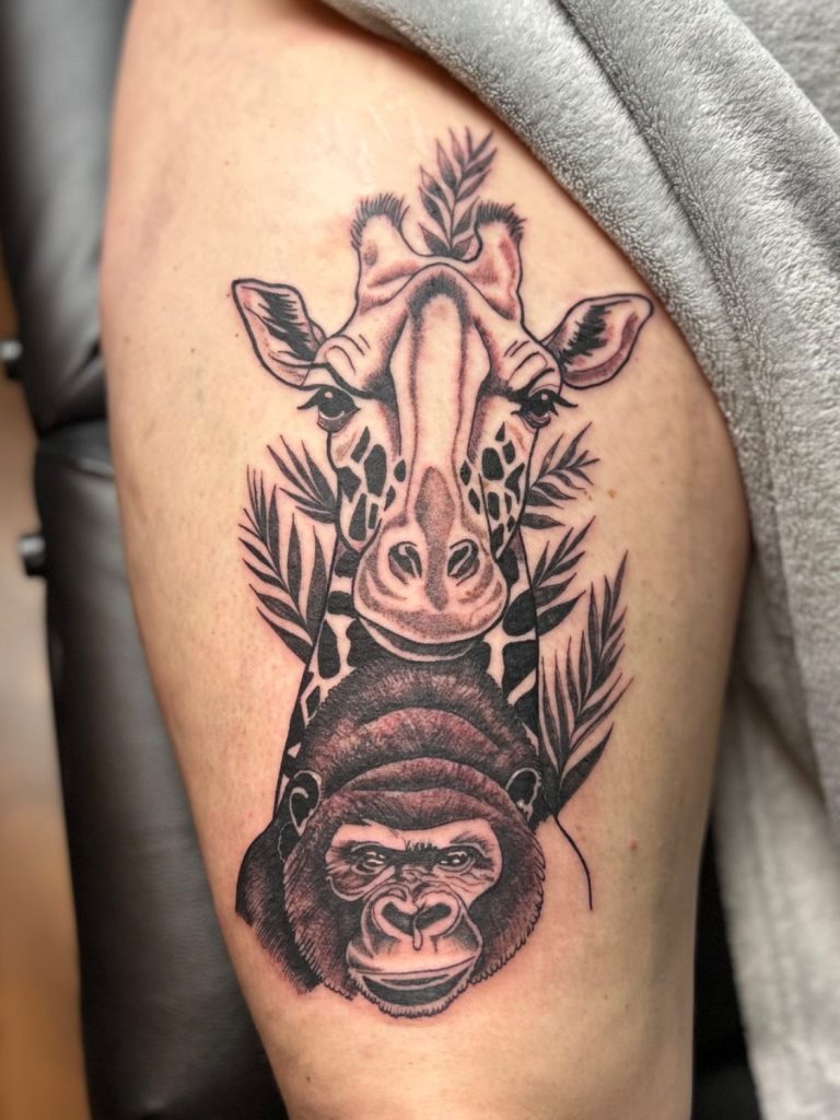 Black and Grey Tattoo mit Giraffe und Gorilla sowie botanischen Elementen